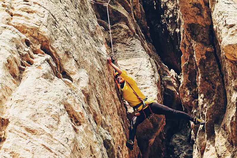 female climber crimping on rock