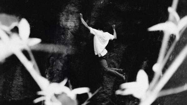 Climber Aidan Roberts climbing boulder in Swtizerland
