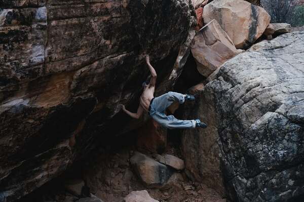 Climber Sean Bailey climbing a hard boulder in Red Rock, Nevada