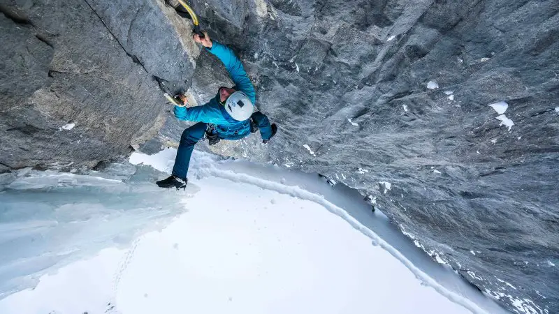 climber Marc Andre free soloing on ice with ice axe and crampons